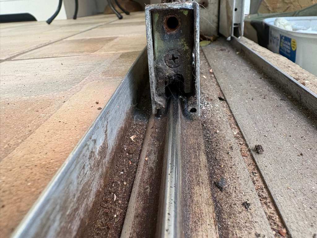 Worn sliding glass door track and bracket before repair